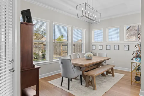 a dining room with furniture a chandelier and wooden floor