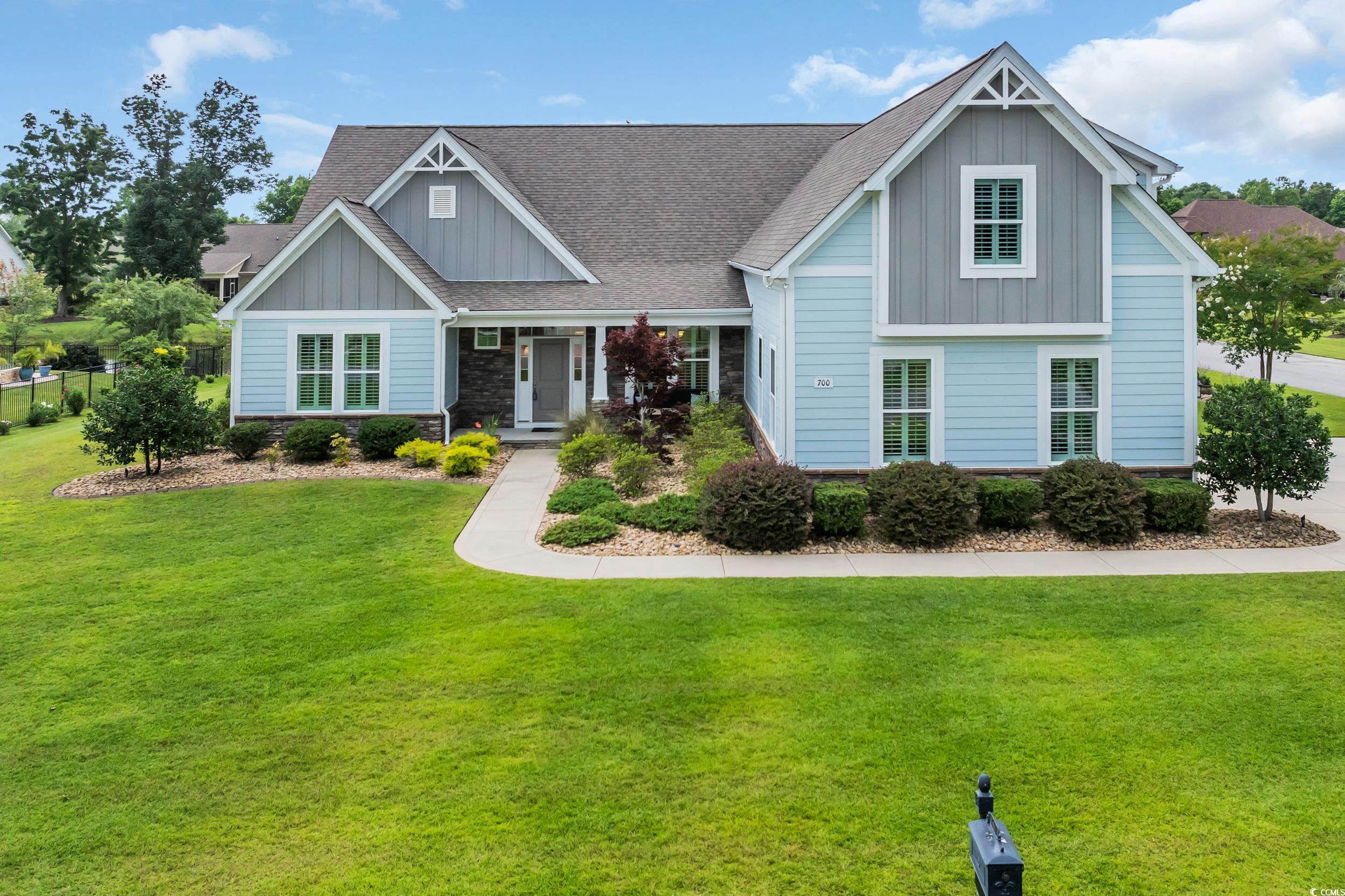 700 Shell Point Court Little River, SC 29566 - Photo 1 of 40 Craftsman-style home featuring board and batten siding, a front lawn, roof with shingles, and stone siding