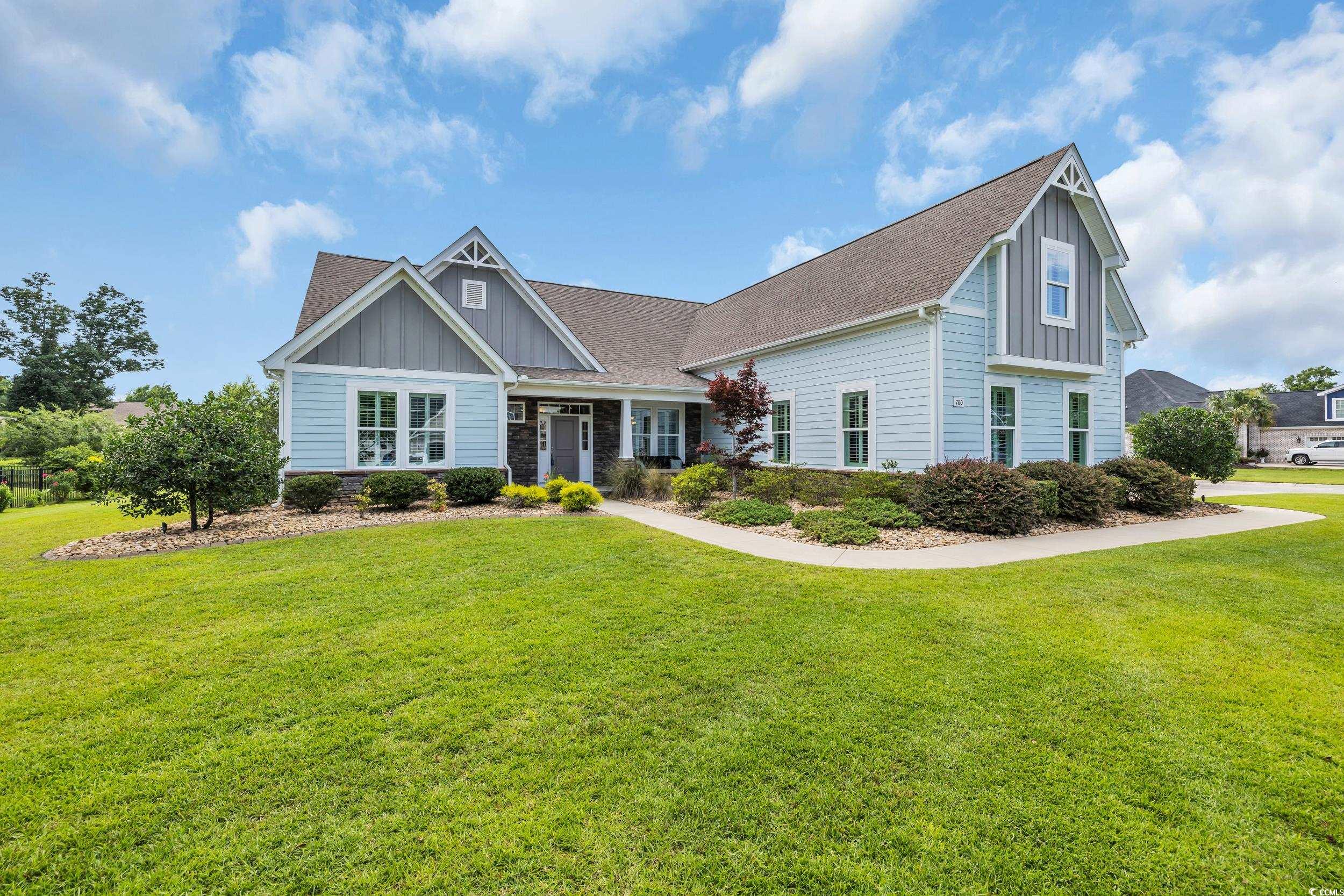 700 Shell Point Court Little River, SC 29566 - Photo 4 of 40 Craftsman house featuring board and batten siding, a front lawn, roof with shingles, and stone siding