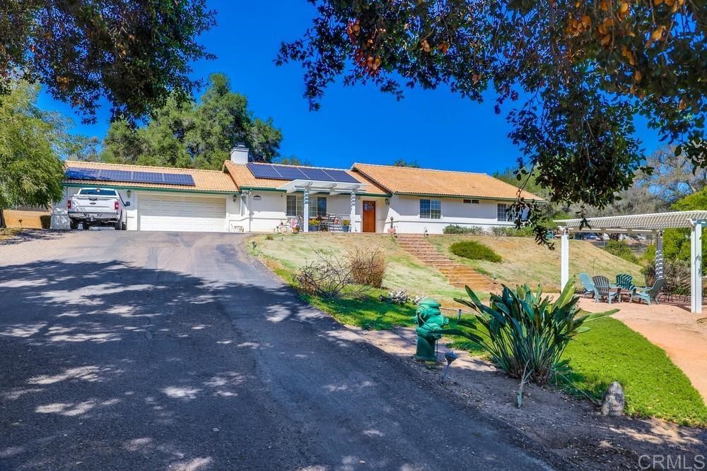 a view of a house with a yard and potted plants