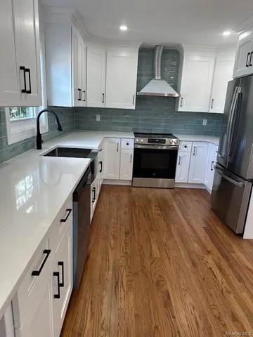 a kitchen with stainless steel appliances granite countertop a stove a sink and a refrigerator