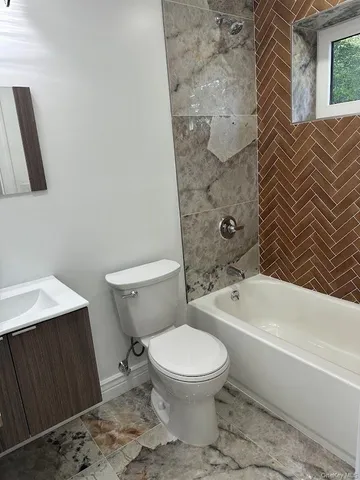 a white toilet sitting next to a bath tub