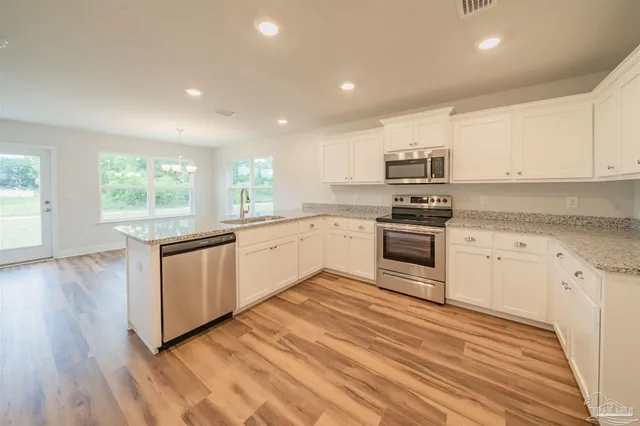 a kitchen with kitchen island sink stove and refrigerator