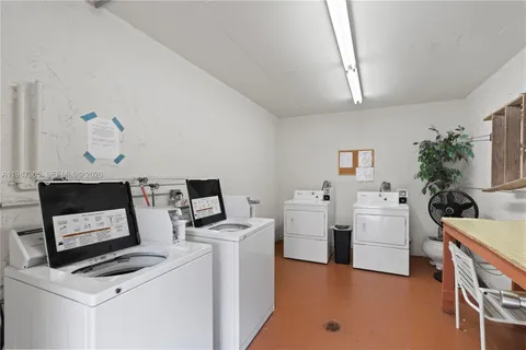 a view of a white house with a yard and potted plants