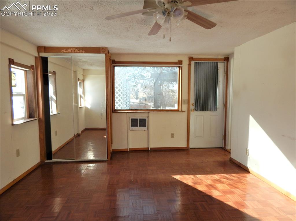 3220 Hoofprint Road Peyton, CO 80831 - Photo 12 of 22 an empty room with wooden floor and windows