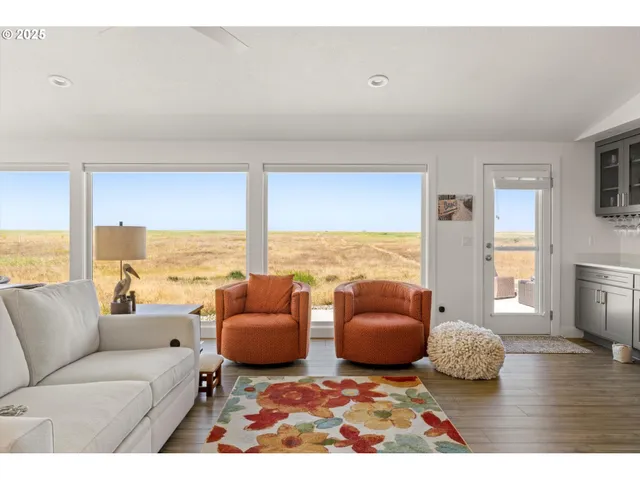 a living room with furniture and floor to ceiling windows