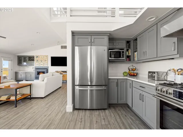 a kitchen with kitchen island a counter top space a sink stainless steel appliances and cabinets