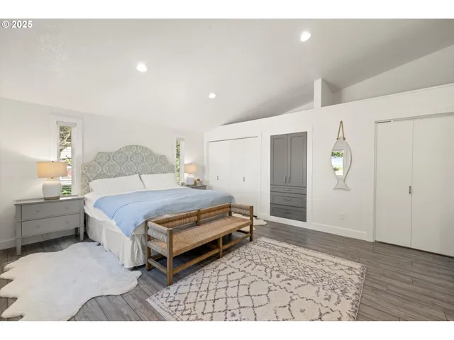 a spacious bedroom with a bed and cabinet