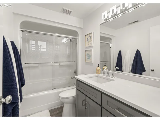 a bathroom with a bathtub shower sink vanity and toilet