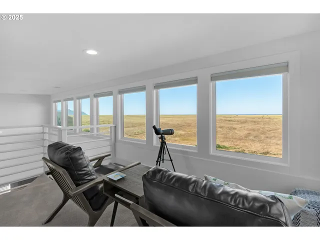 a living room with furniture and floor to ceiling windows