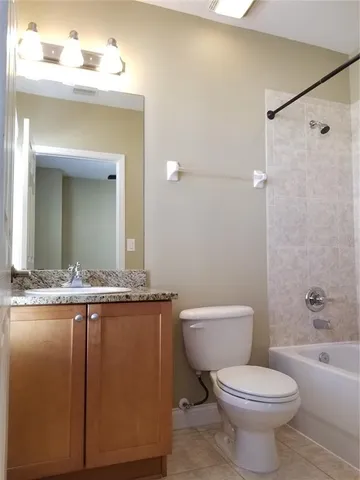 a bathroom with a granite countertop toilet a sink and a mirror