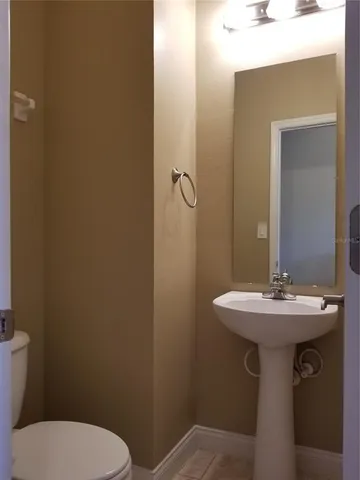 a bathroom with a sink a toilet and mirror