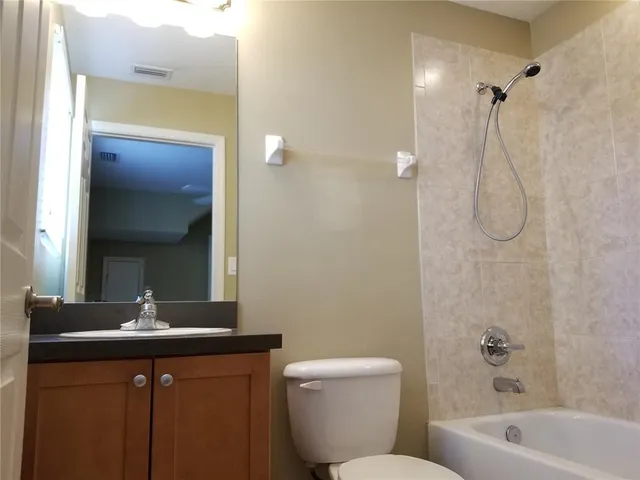 a bathroom with a sink vanity mirror and toilet
