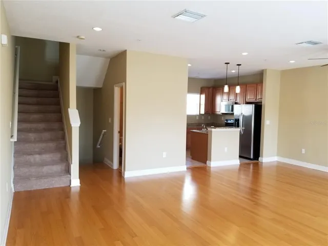 a view of a kitchen with a refrigerator and a stove top oven
