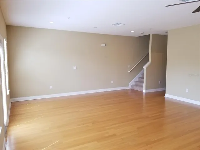 a view of an empty room with wooden floor