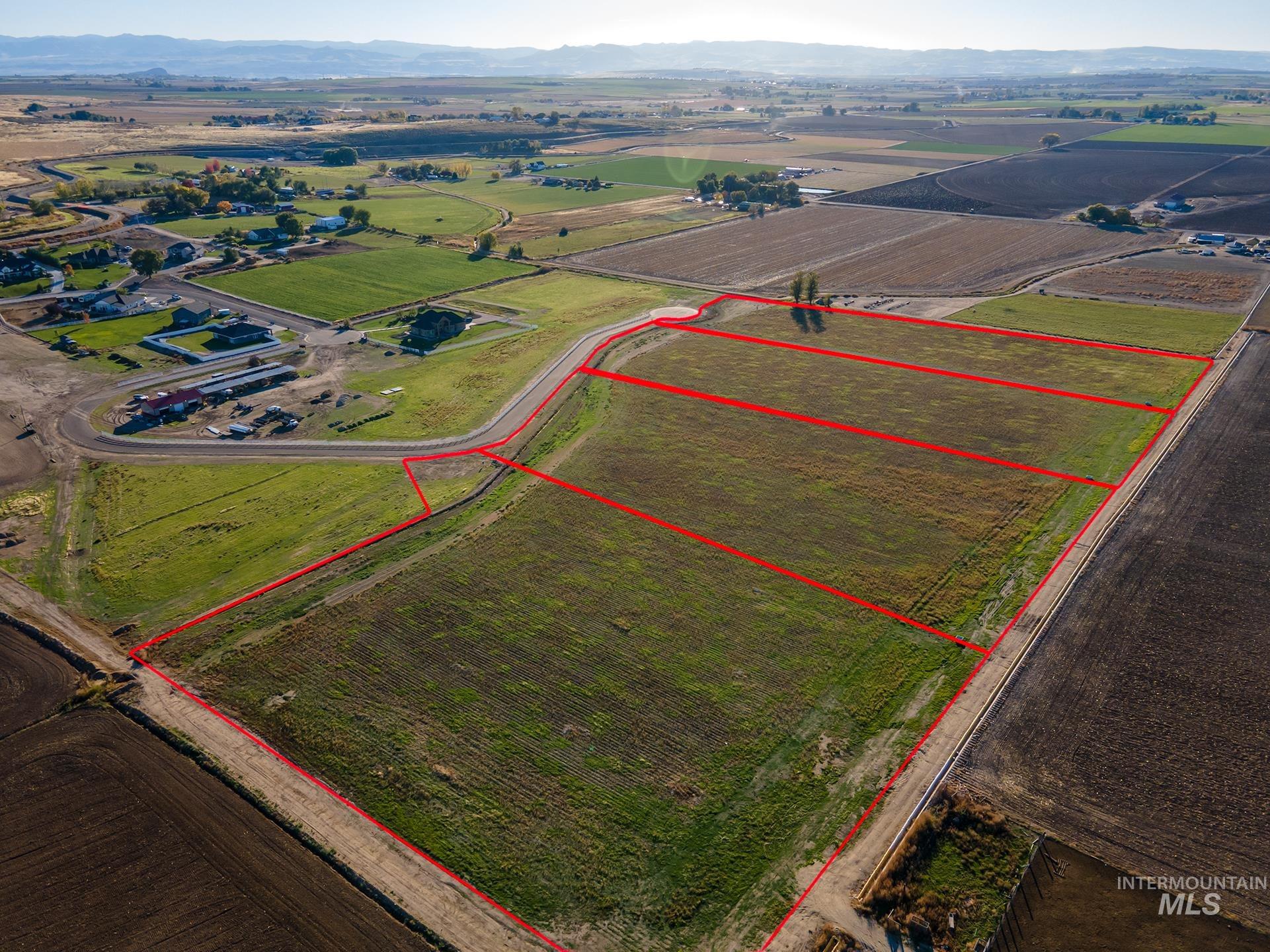 4350 West Mockingjay Kuna, ID 83634 - Photo 5 of 34 Aerial view of sparsely populated area featuring property boundaries highlighted, mountains, and rows of crops