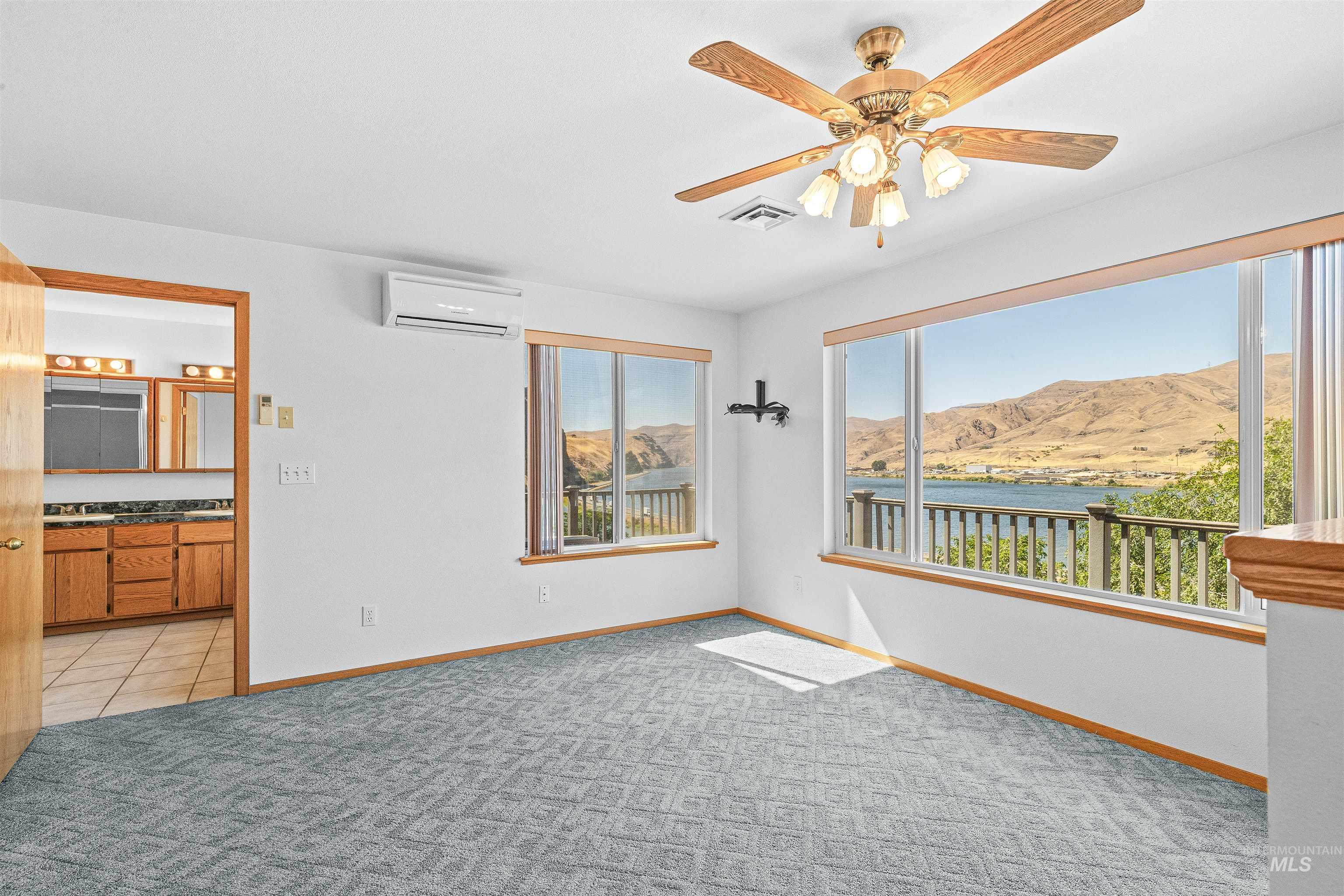 1962 Golfview Drive Clarkston, WA 99403 - Photo 22 of 34 Empty room with a mountain view, healthy amount of natural light, a ceiling fan, and light carpet