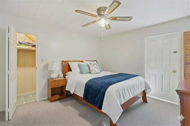 a bed room with a bed and a ceiling fan