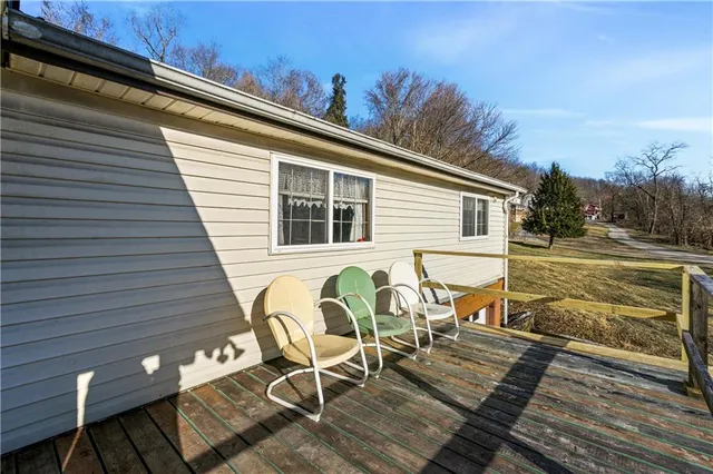 a view of a roof deck with table and chairs with wooden floor and fence