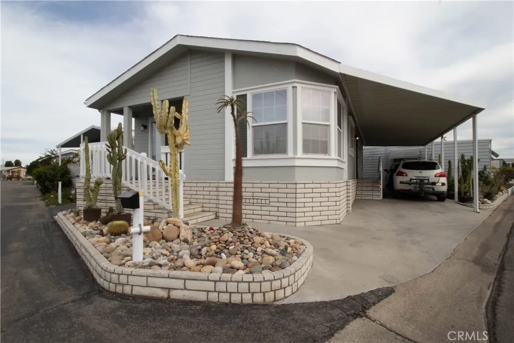 a front view of a house with a garden and parking