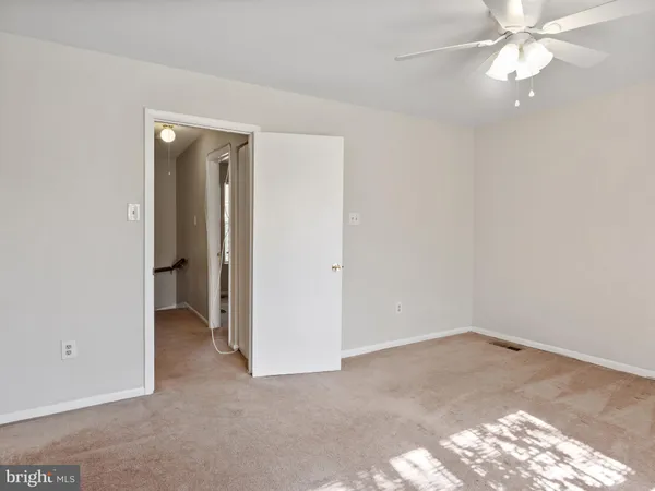 an empty room with closet and a chandelier fan