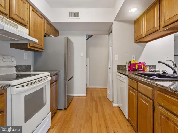 a kitchen with stainless steel appliances a stove a refrigerator and cabinets