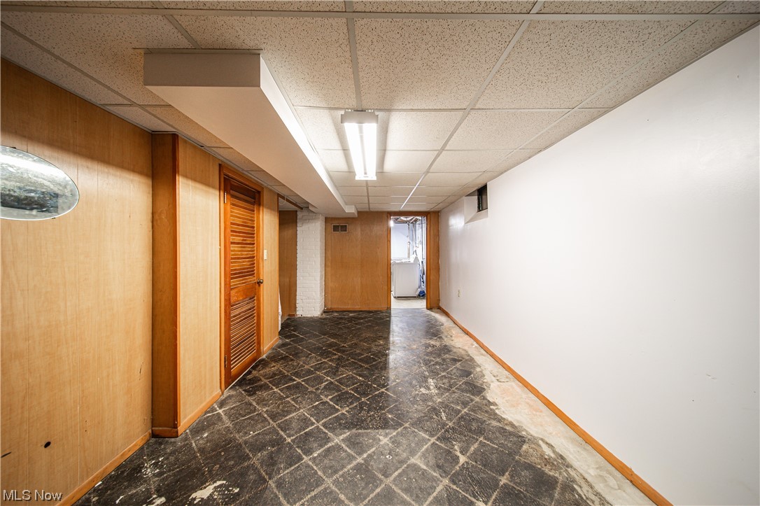 34505 Cannon Road Solon, OH 44139 - Photo 21 of 34 Corridor with dark tile floors, a drop ceiling, and wooden walls
