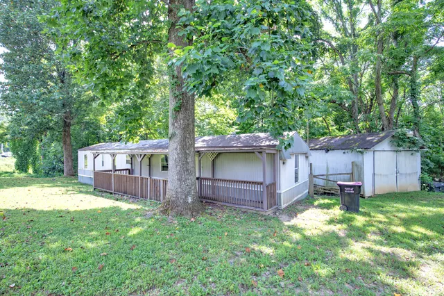 a view of a house with a yard and wooden fence