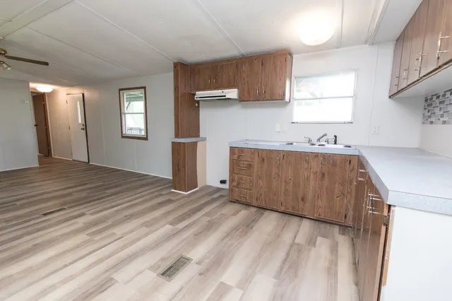 a room with a sink a window and cabinets