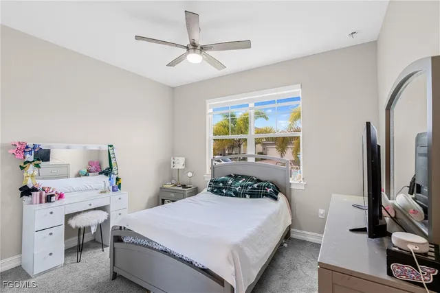 a bedroom with a bed and a flat tv screen on dresser