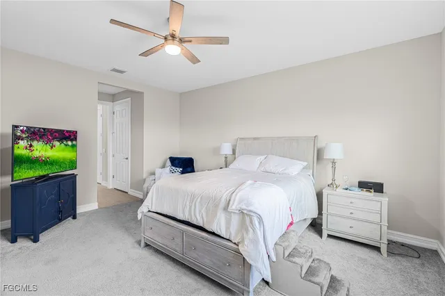 a bedroom with a bed and a flat tv screen on dresser