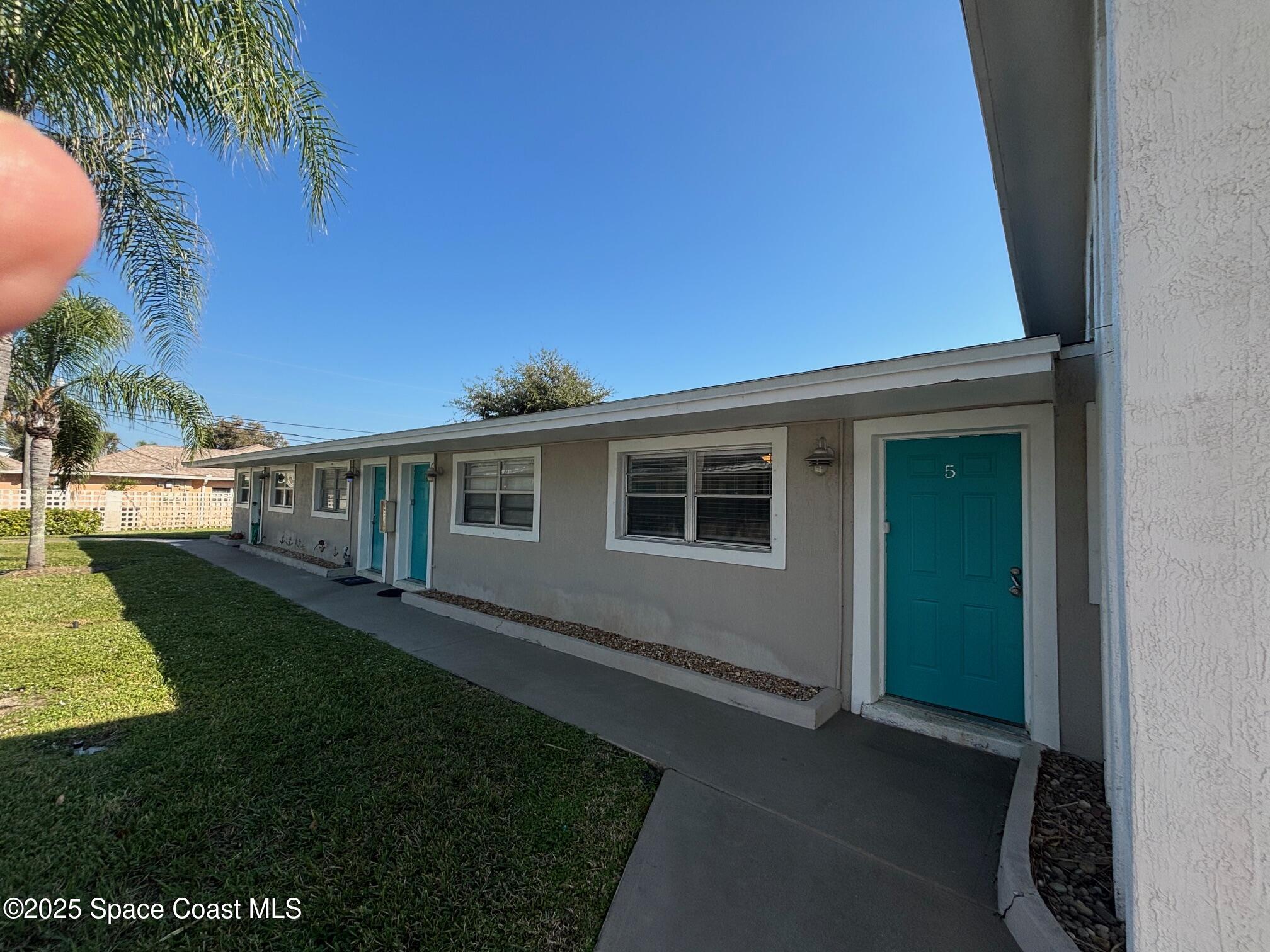306 Johnson Avenue, Unit 5 Cape Canaveral, FL 32920 - Photo 6 of 17 a front view of a house with a yard