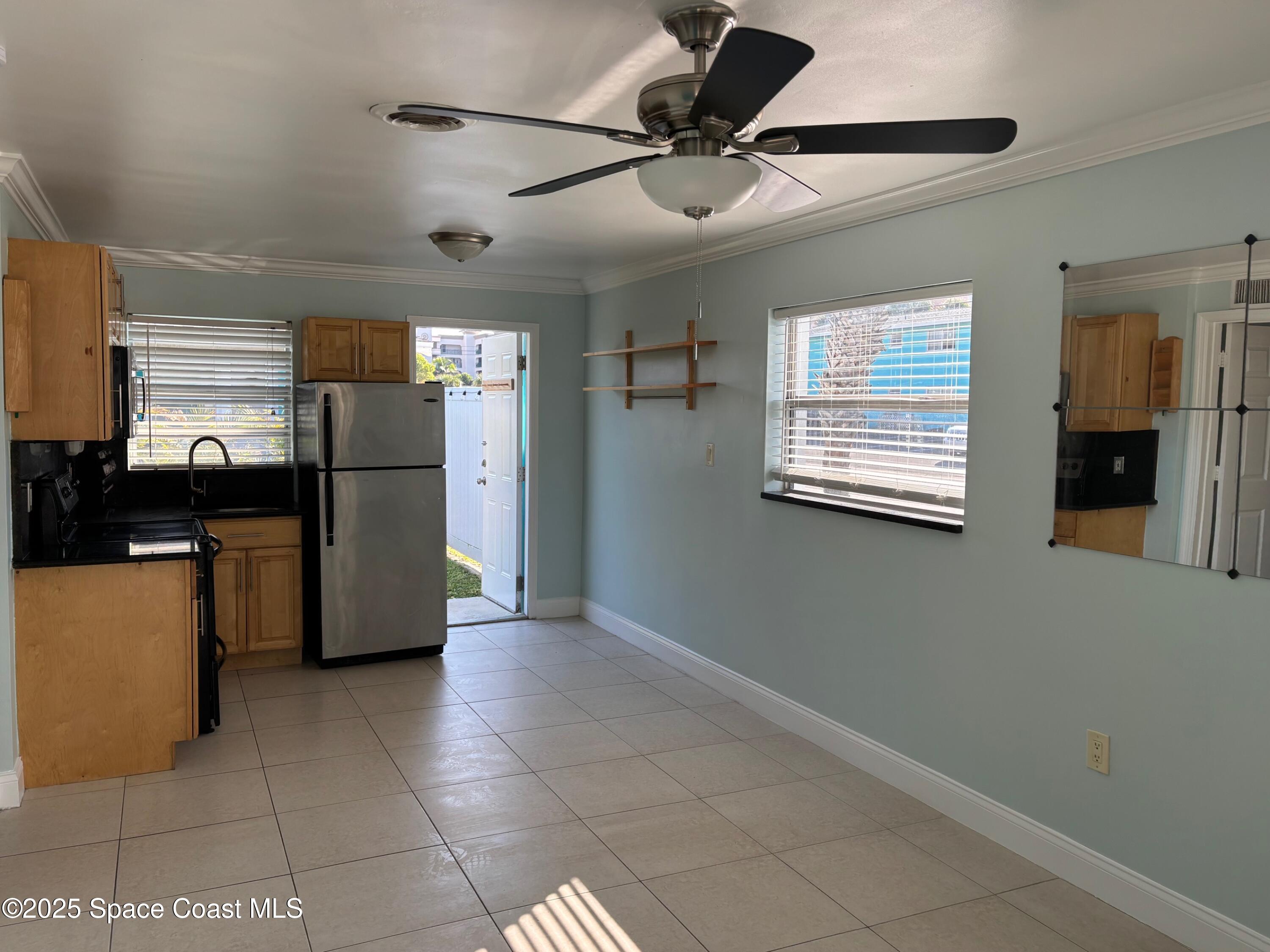 306 Johnson Avenue, Unit 5 Cape Canaveral, FL 32920 - Photo 9 of 17 a view of a kitchen with a sink and a refrigerator