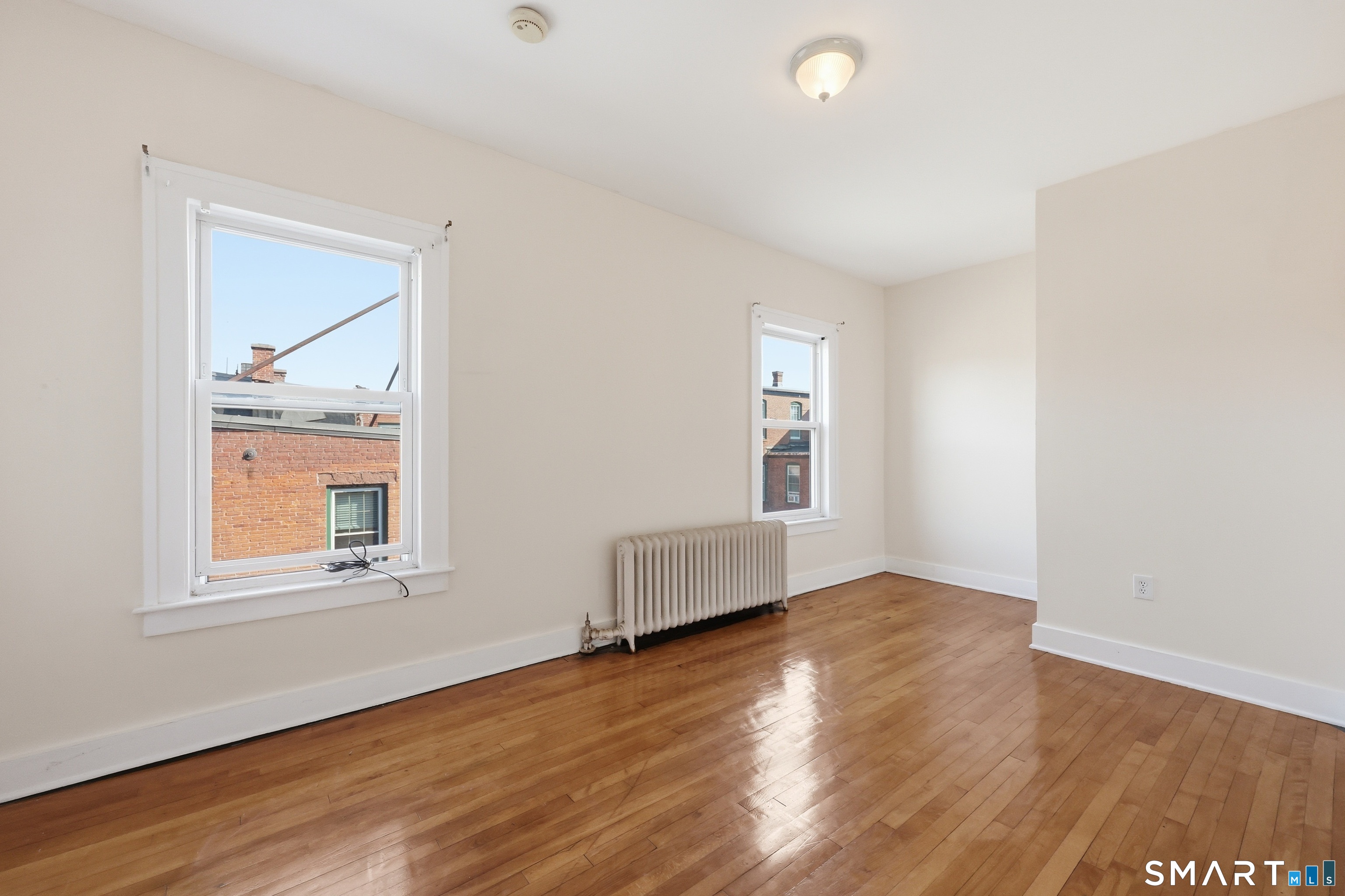 360 Main Street, Unit 3B Middletown, CT 06457 - Photo 6 of 21 an empty room with wooden floor and windows
