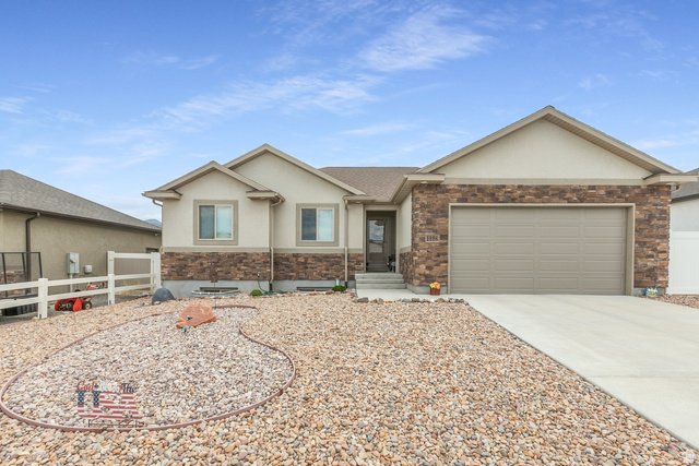1228 North Providence Way Tooele, UT 84074 - Photo 1 of 28 Single-story residence featuring a two-car garage, stone and stucco exterior, and a rock landscaping design