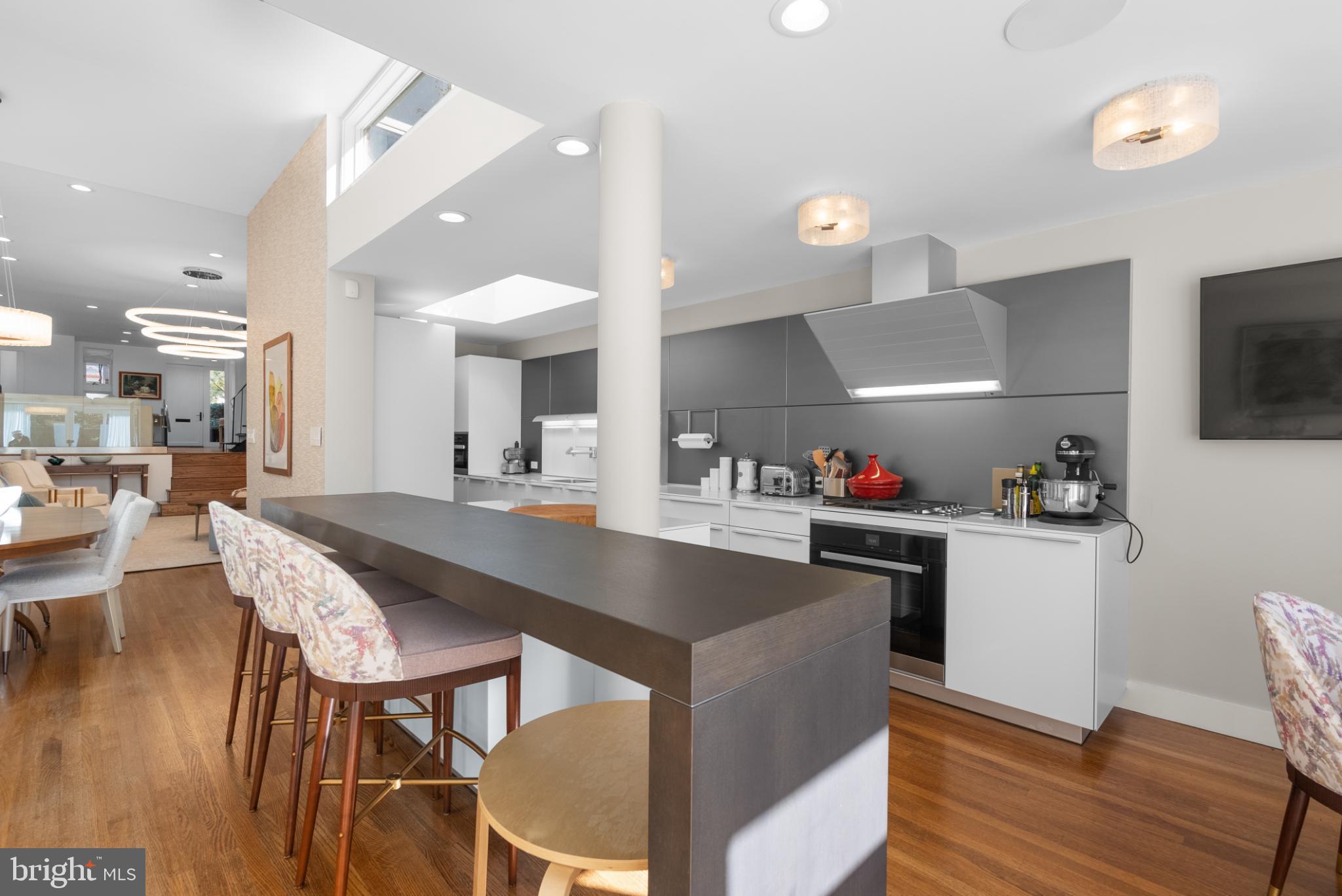 3322 Dent Place Northwest Washington, DC 20007 - Photo 14 of 41 a kitchen with stainless steel appliances granite countertop a table chairs sink and wooden floor