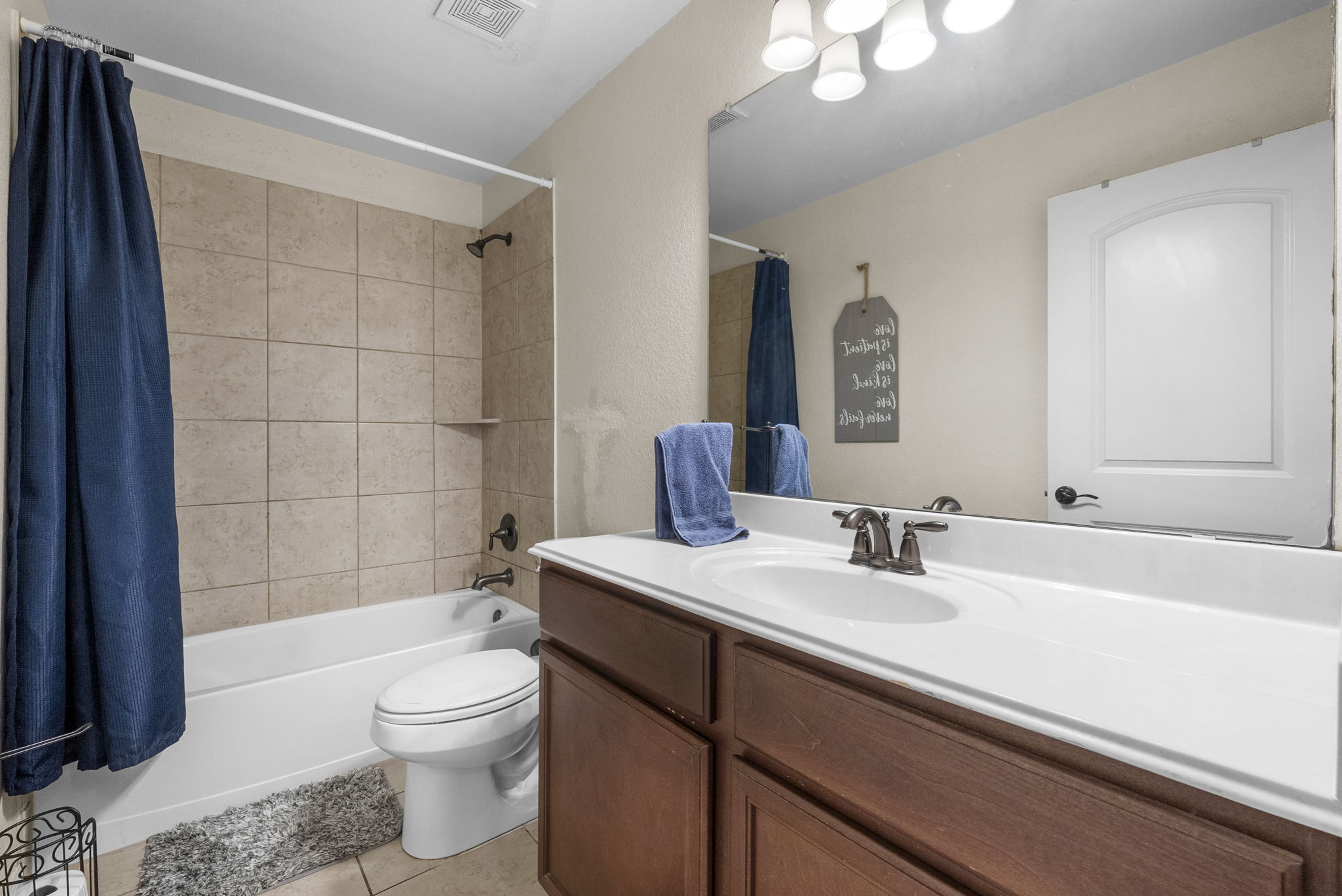 1617 Treeta Trail Kyle, TX 78640 - Photo 21 of 39 Bathroom with vanity, shower / tub combo with curtain, and light tile patterned flooring