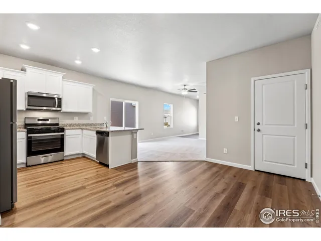 a view of kitchen with wooden floor electronic appliances and window