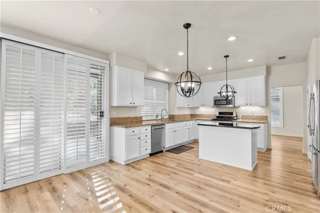a large kitchen with kitchen island a sink stainless steel appliances and cabinets