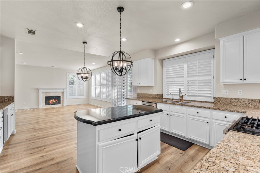 1010 Night Shadow Lane Corona, CA 92881 - Photo 16 of 48 a kitchen with stainless steel appliances granite countertop a sink a stove and a wooden floor