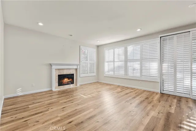 a view of empty room with wooden floor and fireplace
