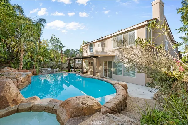 a view of a house with swimming pool and sitting area