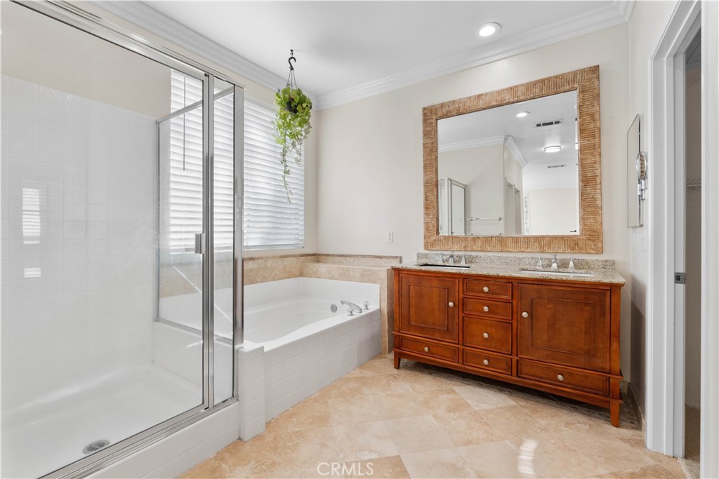 1010 Night Shadow Lane Corona, CA 92881 - Photo 40 of 48 a bathroom with a tub a double vanity sink and a mirror