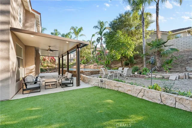 a view of a house with backyard and sitting area