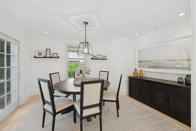 a view of a dining room with furniture a chandelier and wooden floor