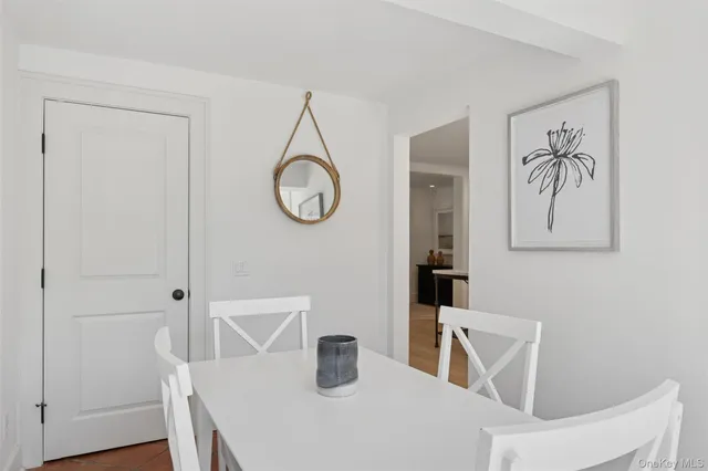 a dining room with wooden floor and white cabinet