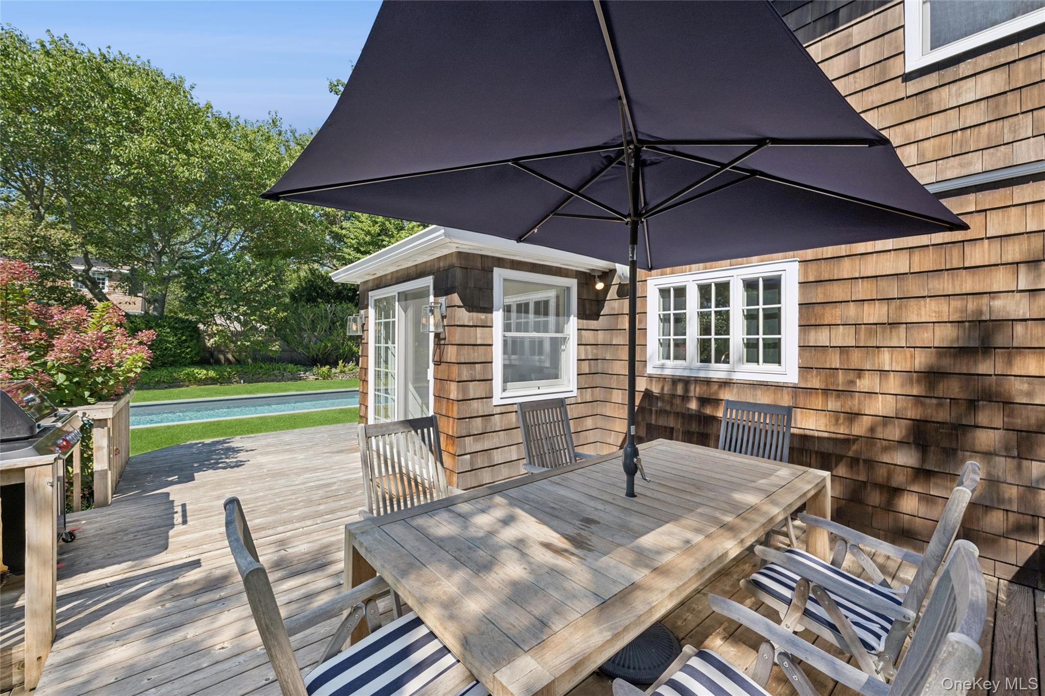 51 Sherrill Road East Hampton, NY 11937 - Photo 32 of 35 a view of a patio with table and chairs under an umbrella