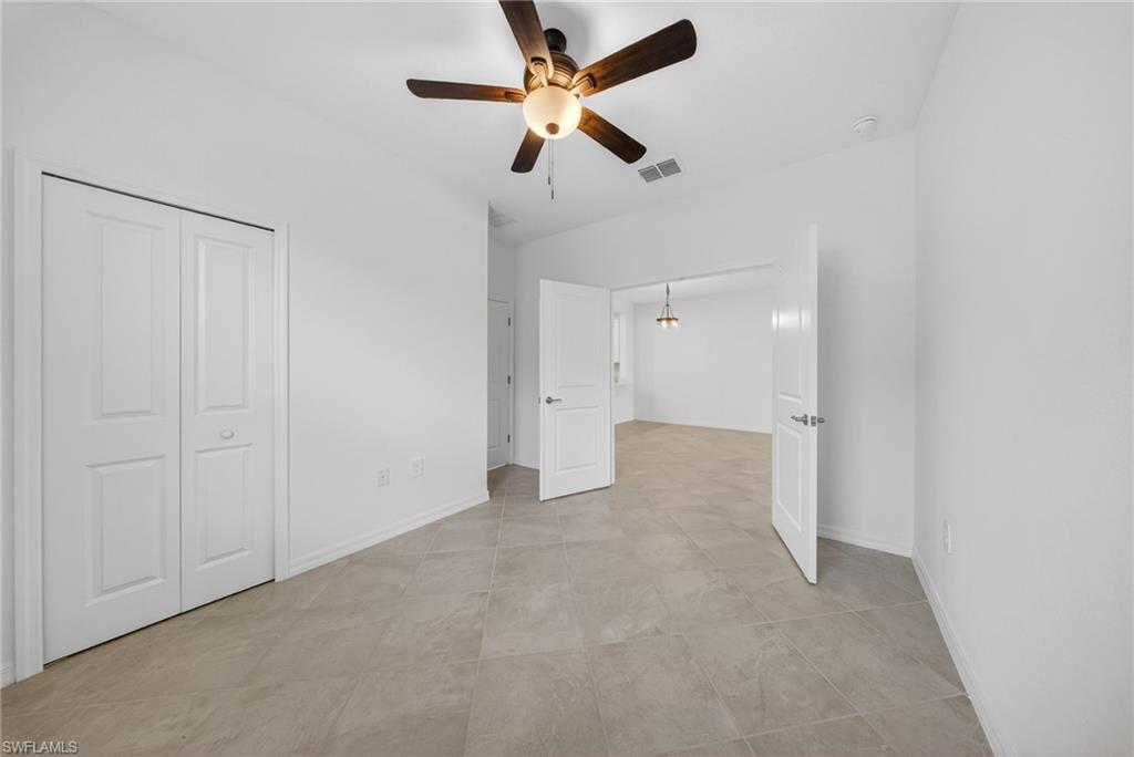 2220 Dragonfruit Way Naples, FL 34120 - Photo 16 of 31 Unfurnished bedroom with a ceiling fan and a closet
