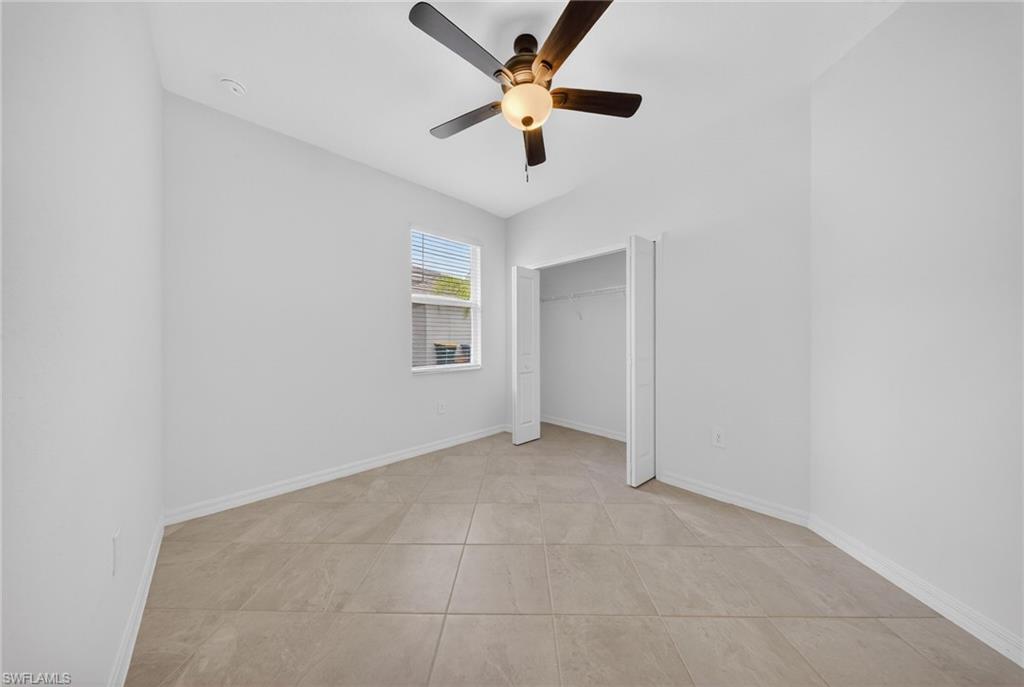 2220 Dragonfruit Way Naples, FL 34120 - Photo 19 of 31 Unfurnished bedroom featuring ceiling fan and a closet