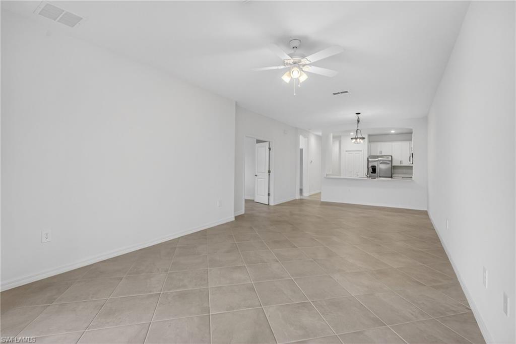 2220 Dragonfruit Way Naples, FL 34120 - Photo 8 of 31 Unfurnished living room with ceiling fan and light tile patterned flooring